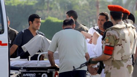 Médicos y policías militares egipcios, escoltan al ex presidente Hosni Mubarak del helicóptero que lo trasladó de prisión  hacia la ambulancia que lo llevaría al hospital militar donde estará  en arresto domiciliario.