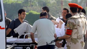 Médicos y policías militares egipcios, escoltan al ex presidente Hosni Mubarak del helicóptero que lo trasladó de prisión  hacia la ambulancia que lo llevaría al hospital militar donde estará  en arresto domiciliario.