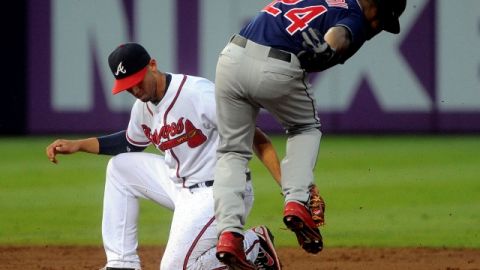 El paracorto de Atlanta,  Andrelton Simmons, no puede aplicar a tiempo el guante sobre Michael Bourn para obtener un doble play.