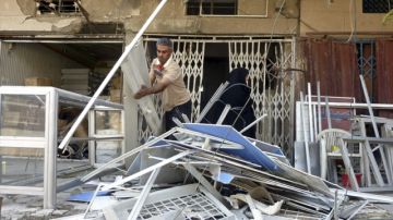 Un ciudadano retiraba escombros en el lugar donde se produjo un atentado en el barrio de Al Shaab, en  Bagdad (Irak).