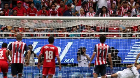 Momento en el que el portero Talavera se lanza para detener el disparo realizado por Márquez Lugo (7) en el juego de ayer en la cancha del Estadio Omnilife.