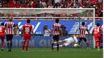 Momento en el que el portero Talavera se lanza para detener el disparo realizado por Márquez Lugo (7) en el juego de ayer en la cancha del Estadio Omnilife.