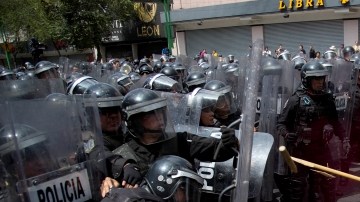 Manifestantes enmascarados chocaban con la policía antidisturbios durante marcha en el Distrito Federal que se dirigía hacia  la Cámara de Diputados, ayer.