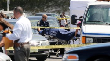 Los expertos forenses retiran los cuerpos de dos personas que resultaron muertas en un hecho de violencia.