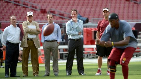 Robert Griffin III es observado por el médico Tony Casolaro (izq.)  y el cirujano James Andrews (2do izq.).