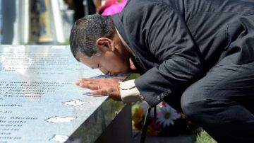 Jaime Ramírez, nieto del trabajador agrícola Ramón Peredes que murió en el accidente aéreo de 1948, besa el nuevo monumento que ahora contiene los nombres de los 28 campesinos fallecidos en el mismo siniestro.