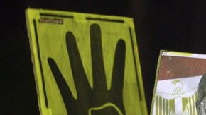 Manifestantes egipcios partidarios de Morsi muestran pancartas con su imagen  en Nasr City, en El Cairo. El cuatro de la pancarta hace referencia a la mezquita más cercana.