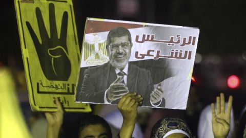 Manifestantes egipcios partidarios de Morsi muestran pancartas con su imagen  en Nasr City, en El Cairo. El cuatro de la pancarta hace referencia a la mezquita más cercana.