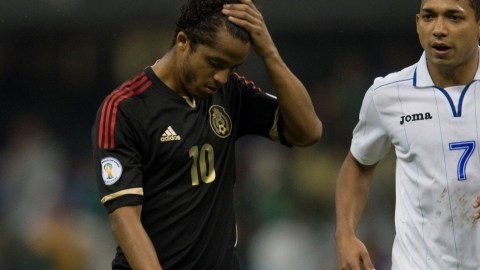 Giovani dos Santos luce incrédulo tras la dolorosa derrota sufrida por la selección mexicana  ante los catra- chos, en el Coloso de Santa Úrsula, que antes era una fortaleza. A su lado pasa Emilio Izaguirre.