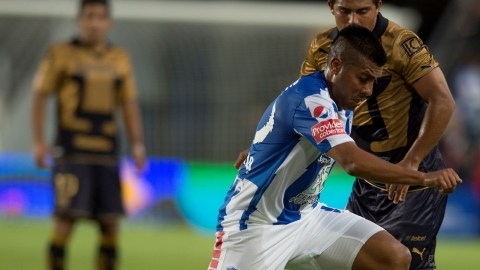 Daniel Ludueña conduce el esférico ante la mirada de un defensa de Pumas de la UNAM, en partido de la fecha 9.