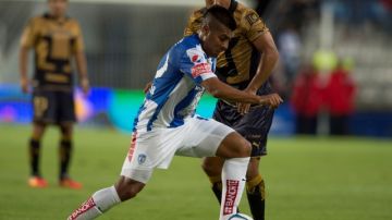 Daniel Ludueña conduce el esférico ante la mirada de un defensa de Pumas de la UNAM, en partido de la fecha 9.