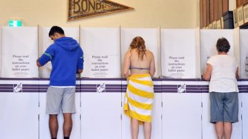 Votantes australianos preparaban sus boletas para votar en la mañana del sábado en  Sidney, Australia.