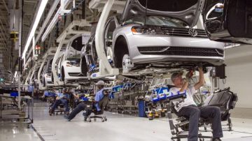 Trabajadores en una planta de producción de autos Volkswagen. Va en aumento demanda de carros.