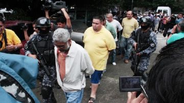 Agentes policiales salvadoreños escoltan a un grupo de 21 personas arrestadas en conexión con el cártel de Texis, en un operativo conjunto con la P