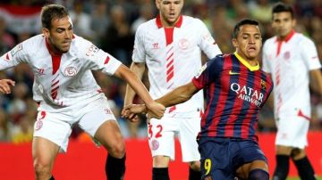 El delantero chileno del FC Barcelona Alexis Sánchez (d) trata de escapar de Fernando Navarro (i), del Sevilla
