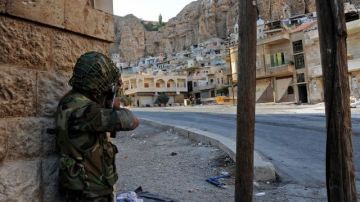Soldados del gobierno sirio se enfrentan a militantes del ELS en una calle de Damasco.