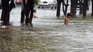 Un niño caminaba ayer en medio de la lluvia  en el puerto de Lázaro Cárdenas, estado de Michoacán (México). La tormenta Manuel y el huracán Ingrid han afectado fuertemente a México