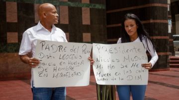 Leocenis García (izq.) y su hija Elena  sostienen pancartas en las que piden a Maduro la  libertad de su  hijo y hermano, respectivamente.