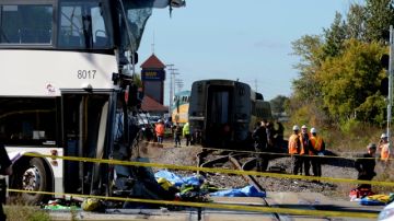 Personal de emergencia observan la escena del choque entre un tren de Via Rail y un autobús de la ciudad de Ottawa, Ontario.