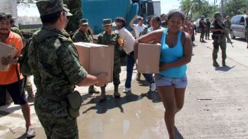 Miembros del Ejército Mexicano reparten víveres a damnificados por las inundaciones en el centro turístico de Acapulco, que está aislado por vía terrestre desde el pasado fin de semana.
