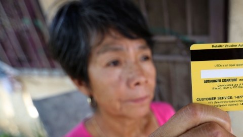 Josefina Delgado muestra su tarjeta de subsidios alimenticios.
