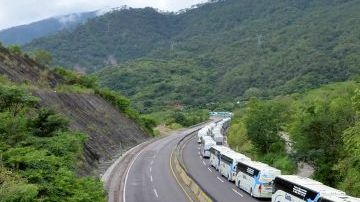 Autobuses se dirigen a recoger turistas a la ciudad de Acapulco por la recién abierta vía que comunica con la Ciudad de México.