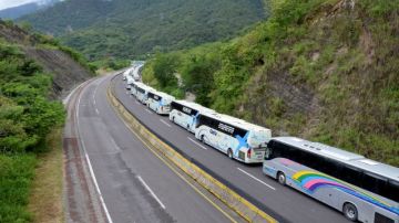 Autobuses se dirigen a recoger turistas a la ciudad de Acapulco por la recién abierta vía que comunica con la Ciudad de México.