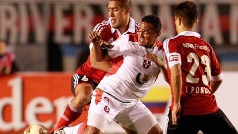 Fabio Renato, de Liga de Loja (c), trata de contolar el balón ante la marca de Leonardo Ponzio (d) y Jonathan Maidana (i), de River Plate argentino.