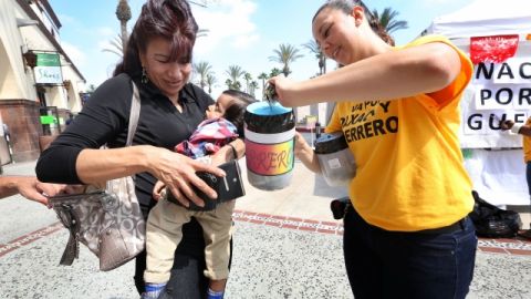 Maria Torres (izq.), con su hijo Liam, dona durante el evento de recaudación en Plaza México, en pro de las víctimas de las tormentas 'Manuel' e 'Ingrid'.
