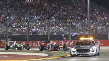 Sebastian Vettel (centro) conduce detrás del auto de seguridad en un tramo del GP de Singapur.