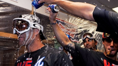 El lanzador Tim Hudson (izq.) recibe feliz su baño de cerveza en las celebraciones de los Bravos en los vestidores del Wrigley Field.