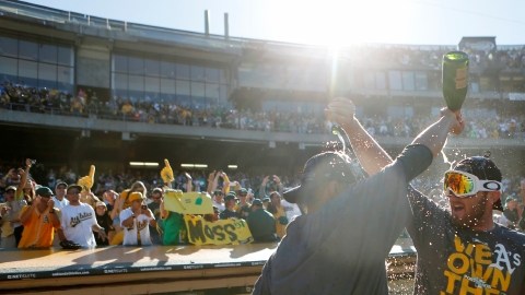 Ryan Cook (der.) y Jesse Chávez festejan con champaña el título divisional de la novena verde-amarilla.