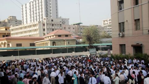 Personas se apresuran a salir de sus apartamentos y oficinas tras el sismo que golpeó ayer a la provincia de Baluchistán, Pakistán.