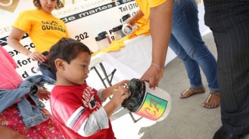 Diego Crisanto, de 2 años, coloca su donativo en la campaña de recolección que hubo en  Plaza México.