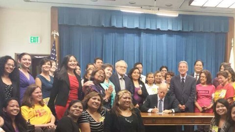 El gobernador Jerry Brown firma la ley que da derecho al pago de horas extras a las trabajadoras domésticas de California.