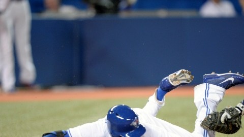 El catcher de Tampa Bay,  José Lobatón, pone fuera de combate en home al corredor de los Azulejos,   Ryan Goins.