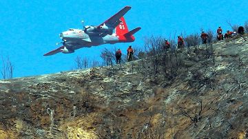 Un avión de extinción de incendios se acerca para sofocar el fuego en las montañas de San Gabriel en Azusa, California, el pasado 24 de septiembre.