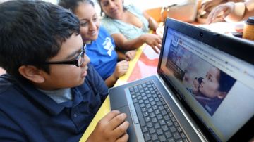 Sayra Galindo y sus hijos Sayali, de 15 años y Hector, de 14, visitan el sitio web de Covered California donde pueden inscribirse para recibir seguro médico.