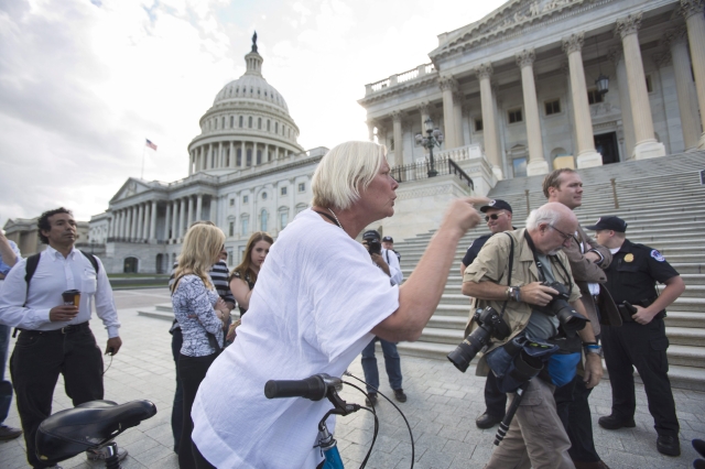 Una ciclista descarga su ira sobre los  congresistas republicanos cuando estos pedían en una conferencia de prensa frente al Capitolio, que  Harry Reid  llame al Senado a votar sobre el  presupuesto.