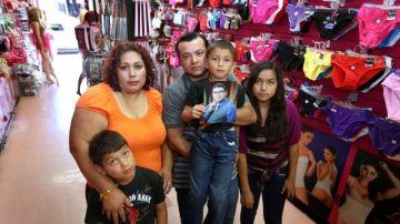 Luis Rivera y su esposa Laura López, junto a sus hijos Lesley (der), 13, Lamuel, 5, and Levy, 9, posan con una foto de su hijo Luis, uno de los "dreamers" que tratará de cruzar la frontera.