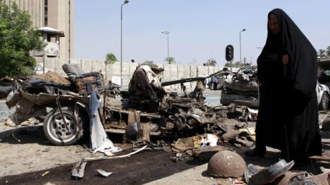 Una mujer iraquí camina por donde se ha registrado un atentado con coche-bomba. Un paisaje de destrucción y muerte.