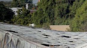 Autoridades del aeropuerto e investigadores frente al hangar que se derrumbó al estrellar una avioneta en el aeropuerto de Santa Monica el domingo por la noche. Los investigadores esperaban la llegada de una grúa el lunes para poder llegar al avión, enterrado por el derrumbe.