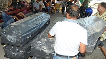 Familiares y amigos preparaban ataúdes, ayer, a las afueras de la morgue de San Pedro Sula, para las cinco víctimas fatales.