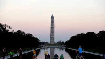 Personas alrededor del espejo de agua en el National Mall, el parque nacional mas visitado de EEUU, en Washington DC, que cerro sus atracciones el martes.