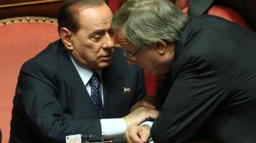 El ex primer ministro italiano y presidente del PDL, Silvio Berlusconi, conversa con el diputado de su partido Altero Matteoli.