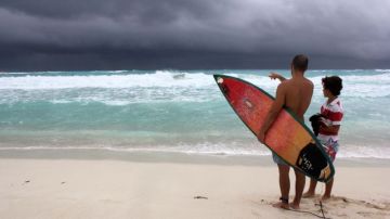 Turistas observan la llegada de la tormenta tropical "Karen" en una playa de Cancún, en el estado mexicano de Quintana Roo.