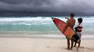 Turistas observan la llegada de la tormenta tropical 'Karen' en una playa  de Cancún en Quintana Roo. La tormenta se formó ayer sobre aguas del Caribe y va tomando fuerzas en el Golfo de México.