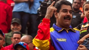 El presidente de Venezuela, Nicolás Maduro (cen.), sostiene a Jorge Alejandro, nieto del fallecido Hugo Chávez, en el festejo.