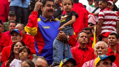 El presidente de Venezuela, Nicolás Maduro (cen.), sostiene a Jorge Alejandro, nieto del fallecido Hugo Chávez, en el festejo.