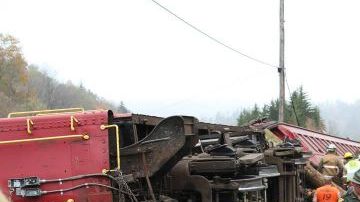 Equipos de emergencia asisten a las personas en el lugar donde un camión que transportaba troncos por Cheat Mountain en la Ruta 250 se estrelló contra un tren que tomaba pasajeros en el condado de Randolph, Virginia Occidental.